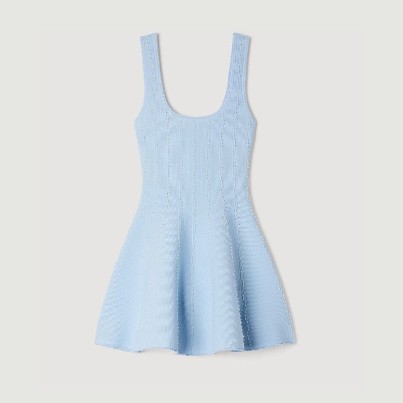 Close-up of delicate bead embellishments on women’s knitted summer dress fabric