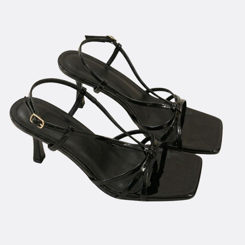 Close-up detail of thin strap black women’s minimalist sandals