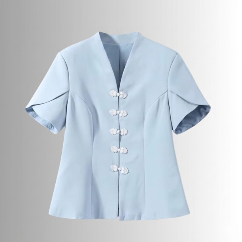 Close-up detail of floral frog buttons on elegant pastel blue women’s blouse
