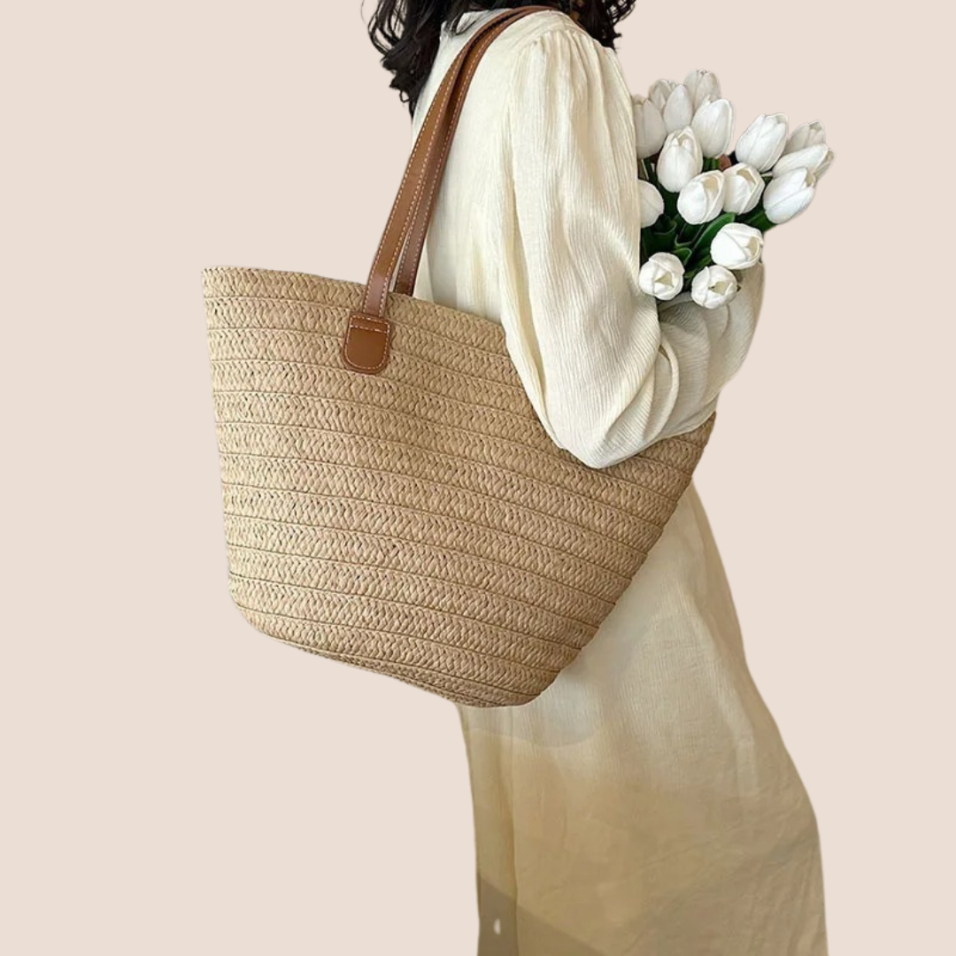 Sac en osier porté par une femme, look estival casual chic avec un sac léger et pratique