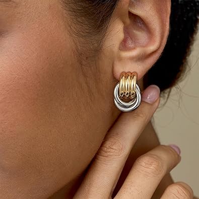 Woman wearing mixed gold and silver earrings, vintage geometric multilayer design, stylish and unique jewelry
