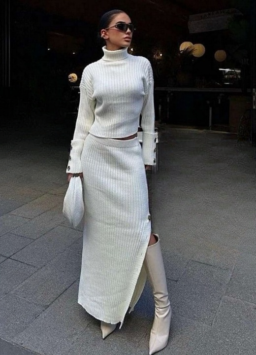 Elegant women’s white knitted set with turtleneck sweater and long slit skirt.