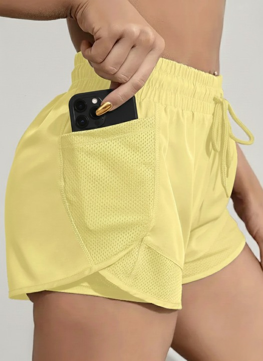 yellow women’s sports shorts with pockets and integrated leggings